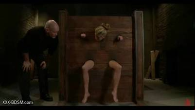 Blonde in wooden clamps gets pussy stimulation